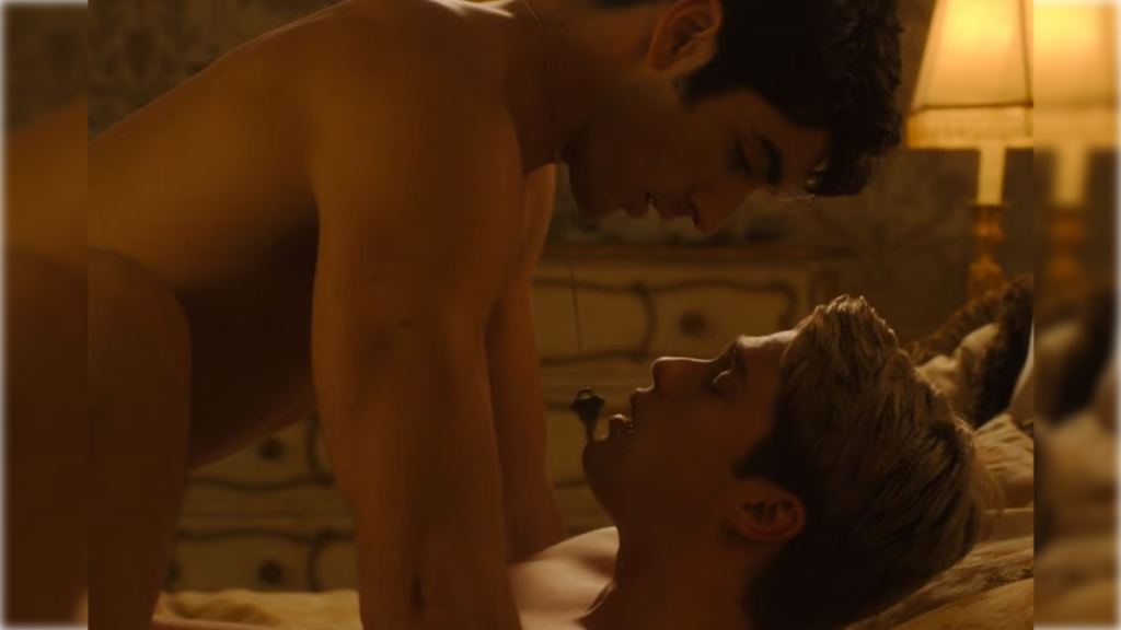 Alex, a Mexican-American man with dark hair is nude on top of Prince Henry, a white blonde male also nude. From the framing of the scene it looks like Alex has penetrated Prince Henry in their first anal sex intercourse. Prince Henry has a look of pleasure on his face as Alex looks directly into his face. A necklace with a simple doorkey hangs from Alex's neck.