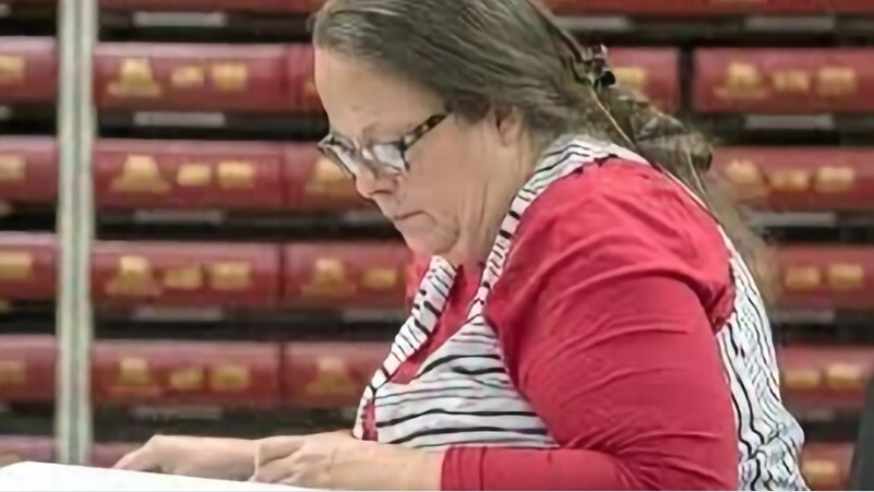Kim Davis looking down at (what can be assumed to be) court documents.