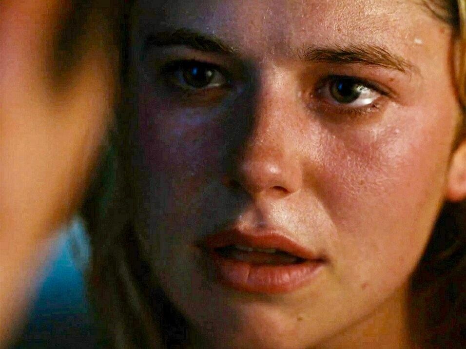 Venetia Catton (Alison Oliver) looks into the eyes of Oliver Quick (Barry Keoghan) her eyes red with tears. Her blonde hair is wet and the eyeliner is starting to blur.